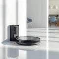 Robot vacuum cleaner on a white surface with a modern room in the background